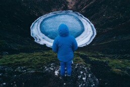 A woman looks keri&eth; crater and its frozen pool