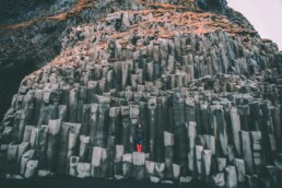 person standing on basalt stacks of Reynisdrangar
